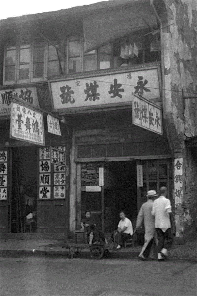 【永安煤店】在煤厂，每天加工煤球的工人不断地摇动大铁筛，他们的工作很累。在蜂窝煤普及之前，中国大陆几