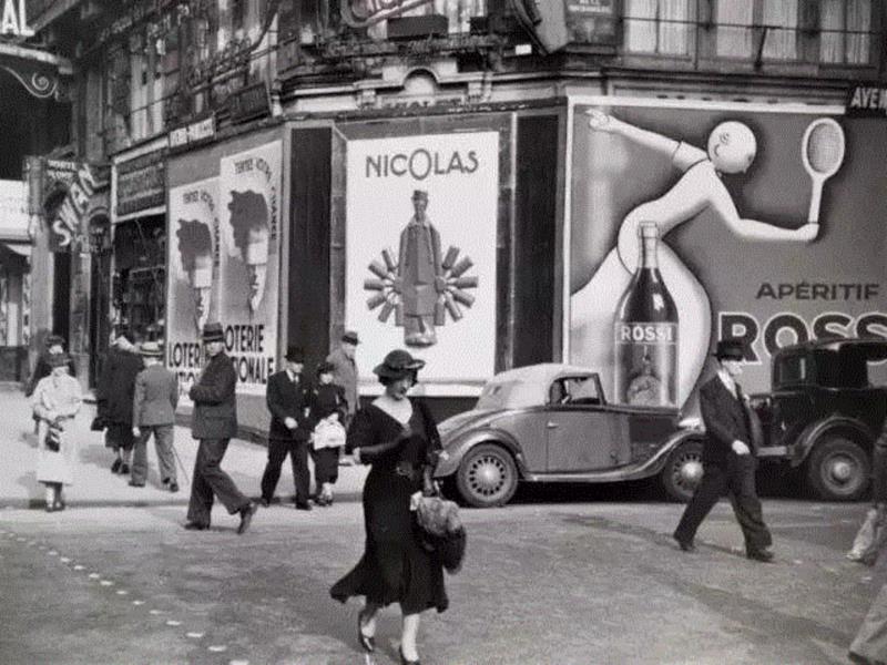 ▲1936年．法国巴黎最时尚地区街头的行人，街道两旁林立着彩票和苦艾酒的广告。梅纳德·欧文·威廉斯/