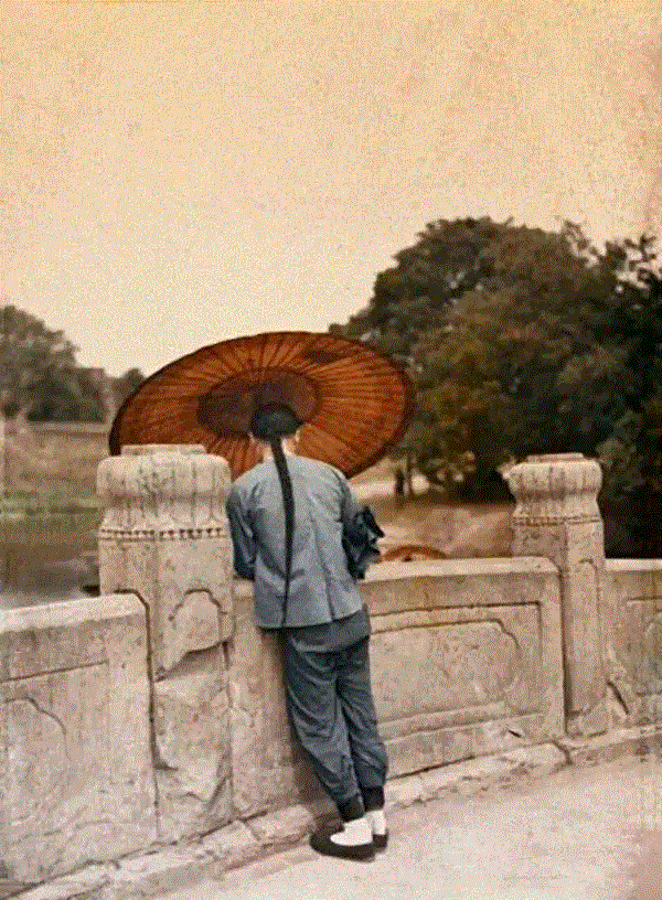      1912年，北京的一座桥上打油布伞的行人。斯特凡?帕塞/摄。,文艺 ▎1年1张，100年北京,天坛,故宫,颐和园,刘英毅,正阳门,城墙,燕京大学,日军,马克,吕布
