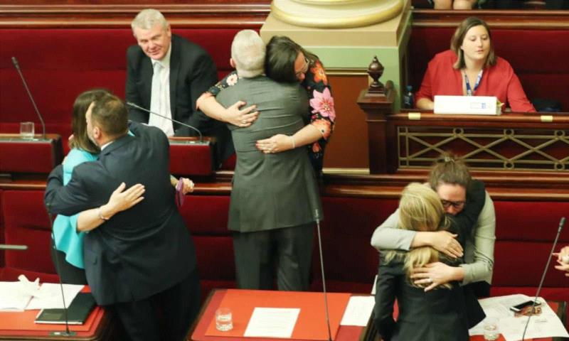 2017年，澳大利亚维多利亚州，《自愿辅助死亡法案》通过后，议员彼此相拥。图源：David Cros