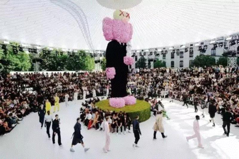 于是，在年中举行的Dior Men首场亮相秀上，Kim找来美国艺术家好友KAWS，在秀场上，一个由粉