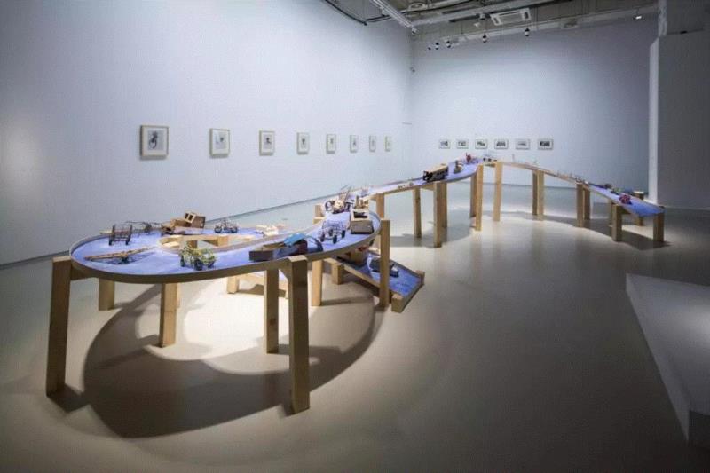 ▲沈远，《蓝色公路》，2003，非洲儿童自制玩具、照片、水彩画、肥皂涂料，900×300×125 c