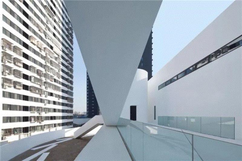 平台的东侧是一个由首层室外庭院的墙体向上伸出的曲面体量，这一空间中通过一个沿墙体上升的楼梯连接首层与
