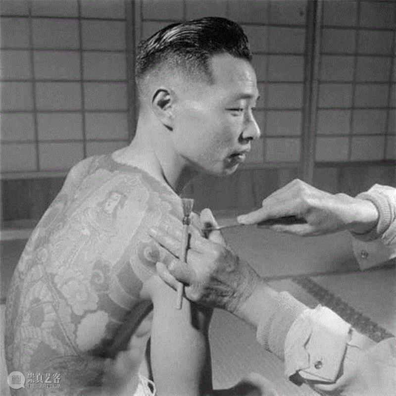 △1946年日本纹身师在黑帮帮派成员的肩上雕纹，注意纹身师左手断指，说明他曾是黑帮成员，但因为背叛组